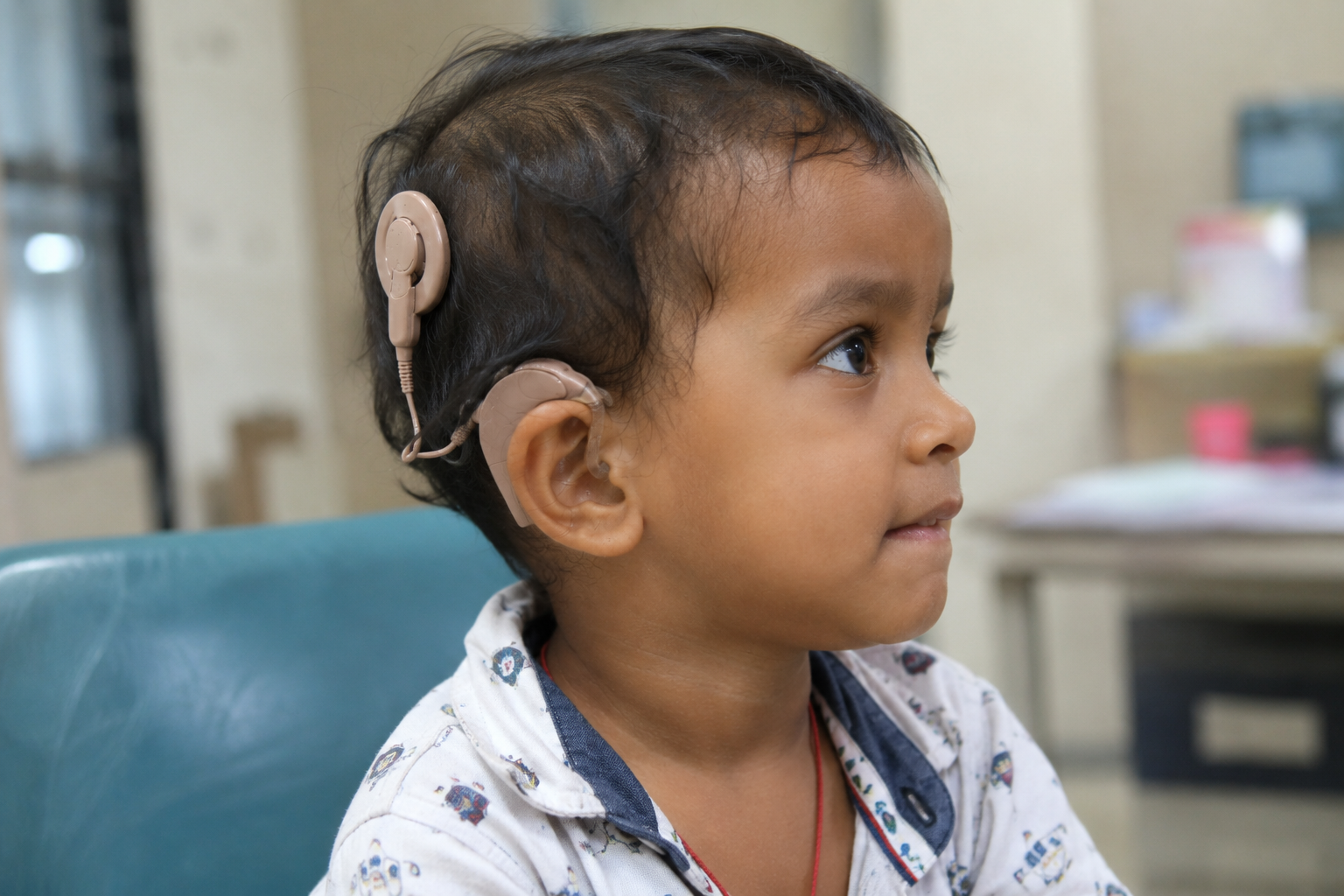 A child laughing joyfully with a cochlear implant